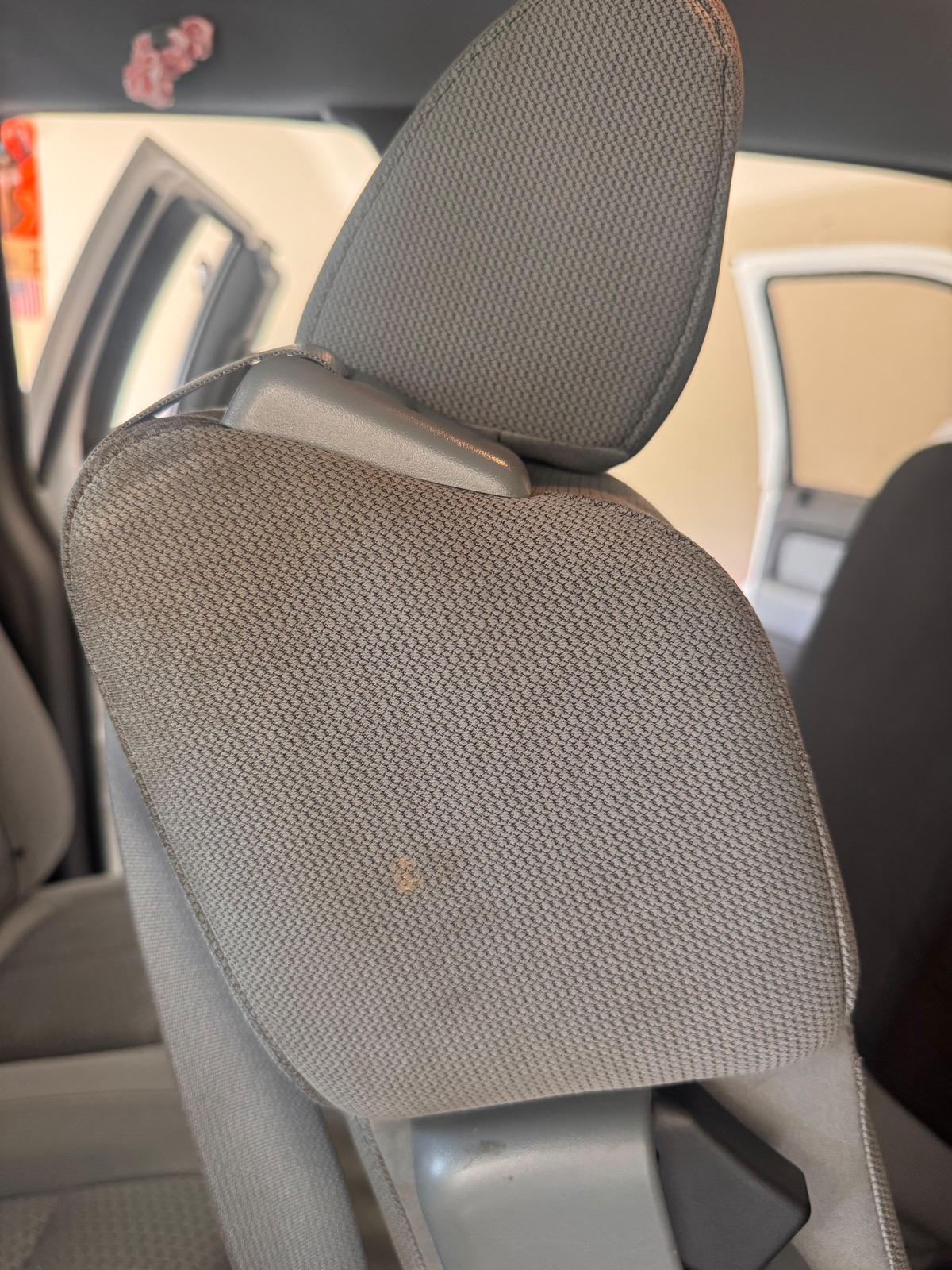 Car headrest with a stain before GraceWell cleaning