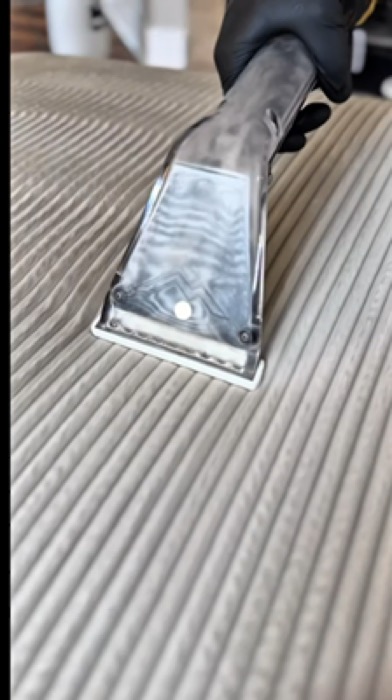 Upholstery cleaning tool in action on a sofa cushion